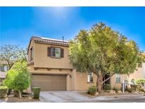 Charming two-story home featuring a two-car garage, desert landscaping, and a shade tree at 5232 Pendergrass St, North Las Vegas, NV 89081