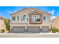Two-story townhouse with three garages, neutral paint, and a small, charming balcony at 8775 Traveling Breeze Ave # 102, Las Vegas, NV 89178