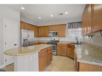 Well-lit kitchen featuring stainless steel appliances, granite counters, and wood cabinets at 9190 Wine Cellar Ave, Las Vegas, NV 89148