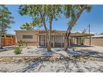 Charming single-story home featuring a carport, desert landscaping, and mature shade trees at 1404 Atlantic St, Las Vegas, NV 89104
