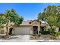 Charming single-story home featuring a two-car garage, tile roof, and landscaped front yard with mature trees at 2958 Lapis Beach Dr, Las Vegas, NV 89117