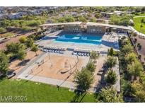Aerial view of a community pool with lounge chairs, splash pad, and green spaces at 462 Fortissimo St, Henderson, NV 89011