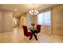 Bright dining area with modern chandelier, glass table, and comfortable red chairs at 462 Fortissimo St, Henderson, NV 89011