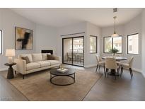Bright living room featuring modern furnishings, fireplace and balcony access overlooking the community at 5032 S Rainbow Blvd # 206, Las Vegas, NV 89118