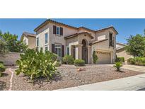 Inviting two-story stucco home with a tile roof, desert landscaping, and a private gated entrance at 1667 Sabatini Dr, Henderson, NV 89052