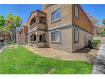 Multi-story condo building featuring stucco exterior and private balconies overlooking landscaped grounds at 201 Mission Laguna Ln # 104, Las Vegas, NV 89107