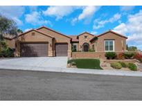 Charming single story home with a terracotta roof, three car garage, and well manicured desert landscaping at 2175 Sandstone Cliffs Dr, Henderson, NV 89044