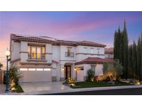 Stunning two-story home featuring a tile roof, balconies, and meticulously landscaped front yard, lit by an elegant street lamp at 2736 Botticelli Dr, Henderson, NV 89052