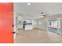 Inviting living room with updated kitchen, stainless appliances, and wood flooring at 3212 Hickey Ave, North Las Vegas, NV 89030