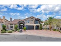 Stunning two-story home with stone accents, tile roof, and a well-manicured front yard with a brick driveway at 4108 Royal Scots Ave, Las Vegas, NV 89141