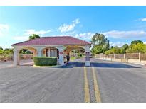 View of the community entrance featuring a red tile roof and neat landscaping at 5429 Sweet Shade St, Las Vegas, NV 89130