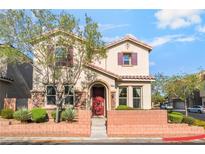Charming two-story home featuring a red door, desert landscaping and a welcoming brick facade at 10917 Mount Pendleton St, Las Vegas, NV 89179