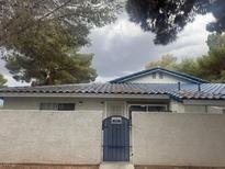 Exterior view of a single story home showcasing a blue tile roof, textured wall and a gated entryway at 2108 Willowbury Dr # B, Las Vegas, NV 89108