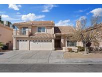 Two-story home featuring a three-car garage, balcony, and desert landscaping at 2812 Via Avanti St, Henderson, NV 89074