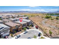 A bird's eye view of a community with well-maintained homes and a winding road. Mountains are in the distance at 330 Spring Dove Ave, Henderson, NV 89011