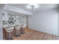 Bright, open kitchen features white cabinets, modern lighting, and a breakfast bar with seating at 3459 One Nation Ave, Las Vegas, NV 89121