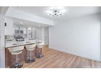 Modern kitchen with white cabinetry, stainless steel appliances, and a breakfast bar with seating at 3459 One Nation Ave, Las Vegas, NV 89121