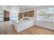 Modern kitchen boasts white countertops, wood cabinets, stainless appliances, and bright, natural light at 5321 Marietta Ave, Las Vegas, NV 89108