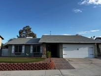 Charming single-story home features a well-maintained front yard and attached two-car garage at 6421 Doby Peak Dr, Las Vegas, NV 89108