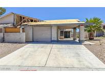 Exterior view of a distressed single-Gathering home with damaged roof and peeling paint at 6723 Oak Valley Dr, Las Vegas, NV 89103