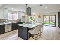 Modern kitchen boasts stainless steel appliances, a large island, and sleek black and white cabinetry at 10009 Coral Sands Dr, Las Vegas, NV 89117