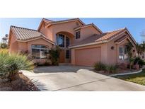 Charming two-story home featuring an attached garage, tile roof, arched windows, and well-maintained landscaping at 2143 Vista Famosa Ct, Las Vegas, NV 89123