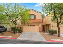 Two story home featuring a two-car garage, drought resistant landscaping and mature trees at 28 Yellow Flame Ave, North Las Vegas, NV 89084