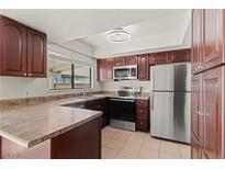 Cozy kitchen featuring stainless steel appliances, brown cabinets, and a window for natural light at 3936 Applecrest St, Las Vegas, NV 89108