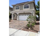 Two-story home featuring a two-car garage and a charming facade with arched windows at 8116 Russell Creek Ct, Las Vegas, NV 89139