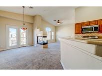Bright living room features a fireplace, neutral carpet, and French doors leading to a balcony at 8717 Tom Noon Ave # 101, Las Vegas, NV 89178