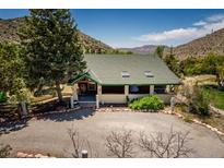 Charming bungalow-style house with a well-maintained yard and a gravel driveway surrounded by nature at 18480 State Hwy 160, Las Vegas, NV 89161