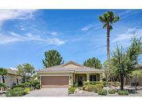 Charming single-story home featuring a well-manicured lawn, mature trees, and a classic desert landscape at 1941 Williamsport St, Henderson, NV 89052