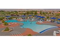 Large community pool with lounge chairs and tables, perfect for relaxing and socializing at 1941 Williamsport St, Henderson, NV 89052