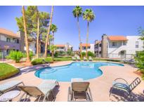 Community pool and lounge chairs surrounded by mature palm trees and manicured landscaping at 2212 Sunfish Dr # C, Henderson, NV 89014
