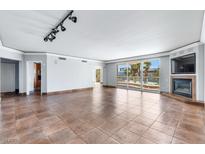 Expansive living room featuring tile floors, a fireplace, and a wall of windows with access to a private balcony at 2857 Paradise Rd # 301, Las Vegas, NV 89109