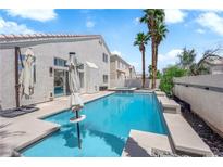 Backyard pool with blue water and palm trees on a sunny day at 4604 Barnes Ct, Las Vegas, NV 89147