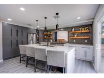 Modern kitchen with gray and white cabinets, stainless steel appliances, and a large center island at 6630 Virtuoso Ct, Las Vegas, NV 89139