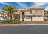 Charming two-story home featuring a well-manicured lawn, a palm tree, and a two-car garage at 8970 Lansberry Ct, Las Vegas, NV 89147