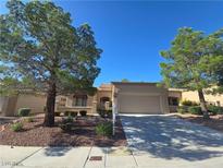 Charming single-story home with a well-manicured front yard and inviting curb appeal, set beneath a clear blue sky at 9329 Fresh Spring Dr, Las Vegas, NV 89134