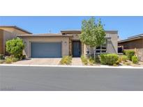 Charming single-story home with a blue door, blue garage door, a small tree, and manicured landscaping at , Las Vegas, NV 89148