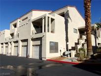 Exterior shot of condominium building featuring attached garages, stairs, balconies and desert landscaping at 3827 Desert Marina Dr # 211, Laughlin, NV 89029