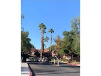 View of the gated community entrance with mature trees and lush landscaping, offering privacy and curb appeal at 4050 Pacific Harbors Dr # 149, Las Vegas, NV 89121