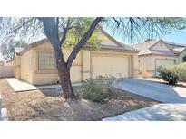 Single story home with a tan exterior, low maintenance desert landscaping, and two car garage at 6516 Velvet Silk St, North Las Vegas, NV 89084