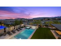 Beautiful pool and patio area with lounge chairs and mountain views at dusk at 12637 Penfield Ave, Las Vegas, NV 89138