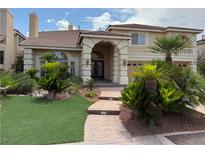 Elegant two-story home featuring a well-manicured lawn, lush landscaping, and a stately entrance with stone accents at 4139 Abernethy Forest Pl, Las Vegas, NV 89141