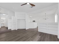 Bright living room features hardwood floors, a ceiling fan, and custom built in shelving at 4807 Leadership Ct, North Las Vegas, NV 89031