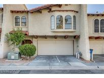 Charming townhome with a two-car garage, desert landscaping, and arched windows at 4998 Schumann Dr, Las Vegas, NV 89146