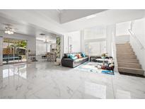 Bright, open-concept living room with high ceilings, modern decor, and ample natural light at 5332 Desert Blossom Rd, Las Vegas, NV 89107
