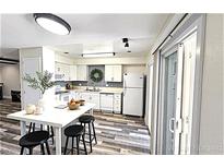 Bright kitchen boasts white cabinetry, stainless steel appliances, and a center island with seating at 708 Fernwood Ln, Las Vegas, NV 89169
