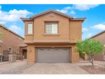 Two-story home featuring a brown garage door, complementary tan-colored walls, and a well-maintained yard at 765 Crimson Peak Pl, Henderson, NV 89011